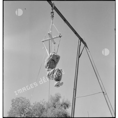 Un soldat de la 25e division alpine (DA) s'entraine au saut en parachute à l'aide d'une structure en bois.