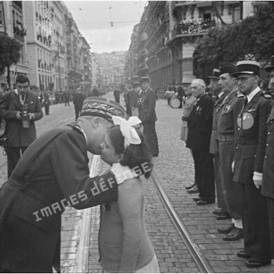 Le général Olleris embrasse une fillette lors de le cérémonie de commémoration du 11 novembre à Alger.