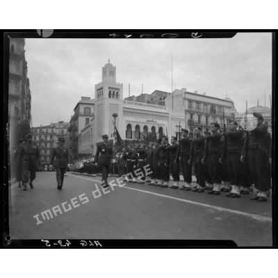 Le général Georges Catroux passe les troupes en revue, à Alger, devant le bâtiment du journal Alger républicain.