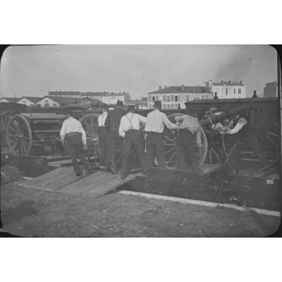 [Artilleurs arrimant des pièces d'artillerie sur un wagon plateforme, 1871].