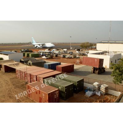 Derrière une zone de regroupement logistique, un avion-cargo de transport Antonov 124-100 ukrainien stationne sur une piste de l'aéroport de Bamako.