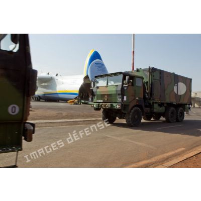 Pendant le déchargement du fret de la soute d'un avion-cargo de transport Antonov 225 ukrainien, passage d'un camion TRM-10000 porte-shelter.