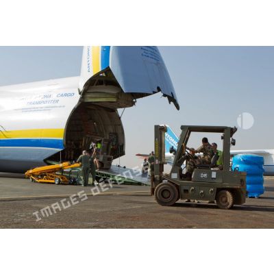Déchargement de palettes de pneus de la soute d'un avion-cargo de transport Antonov 225 ukrainien par un engin manutention transpalette OM du RTP (régiment du train parachutiste). En arrière-plan, un avion-cargo de transport Antonov 124-100 ukrainien.
