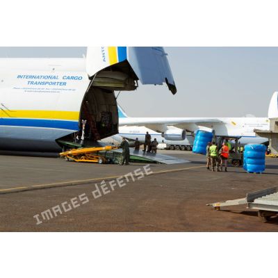 Déchargement de palettes de pneus de la soute d'un avion-cargo de transport Antonov 225 ukrainien par un engin de manutention transpalette OM du RTP (régiment du train parachutiste). En arrière-plan, un avion-cargo de transport Antonov 124-100 ukrainien.