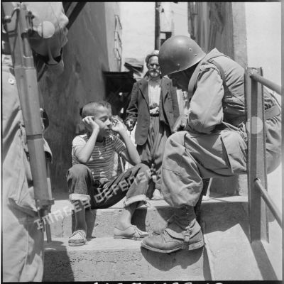 Un tirailleur sénégalais en conversation avec un enfant dans la Casbah d'Alger.
