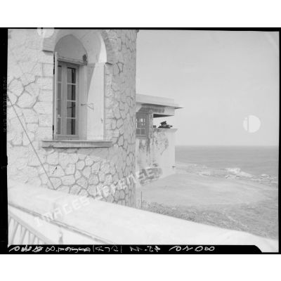 Vue de profil de l'homme de quart à la veille, dans une tour d'un sémaphore, face à la mer.