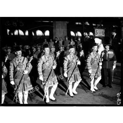 Le défilé des musiciens de la Garde royale anglaise sur les quais de la gare du Nord. [légende d'origine]