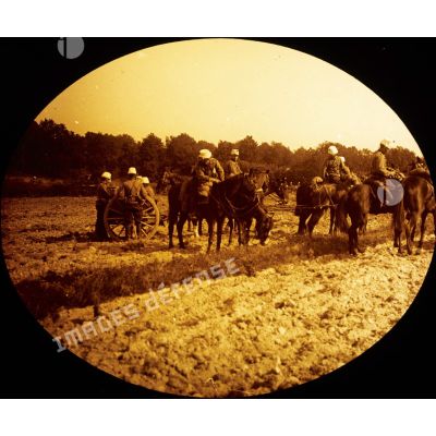 [Troupe d'artillerie tractant un canon à l'aide de chevaux stationnant sur un champs pendant les grandes manoeuvres de septembre 1912.]