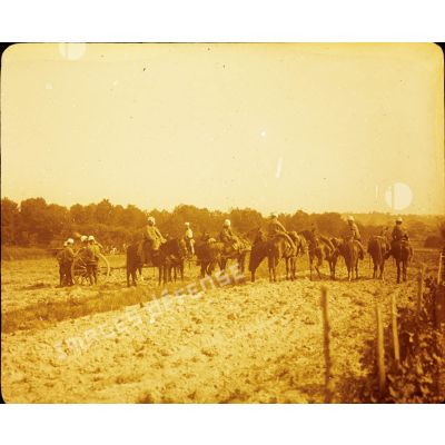 [Troupe d'artillerie tractant un canon à l'aide de chevaux stationnant sur un champs pendant les grandes manoeuvres de septembre 1912.]