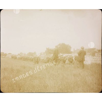 [Troupe d'infanterie alignée derrière un muret en position de tir lors des grandes manoeuvres de septembre 1912.]