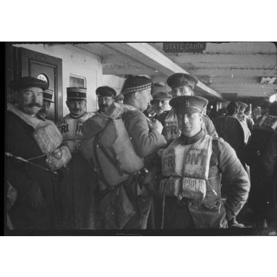 [Membres d'une commission française en compagnie de soldats de la marine britannique sur un navire, s.d.]