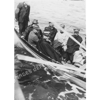 [Jules-Louis Breton et une délégation d'officiels sur une barque lors d'une visite sur un site naval.]
