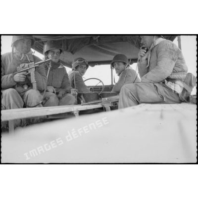 Vie quotidienne au 8e RIM. Portrait d'un groupe de soldats assis à l'arrière d'un camion militaire. [légende d'origine]