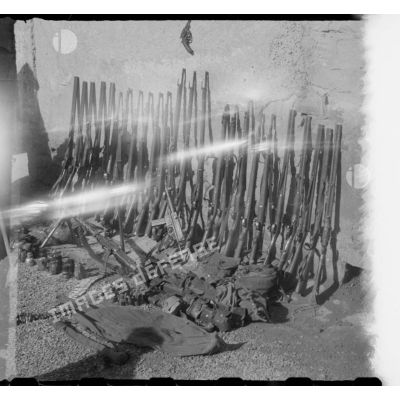 Dans une cour, exposition du materiel et de l'armement récupérés par les soldats du 8e RIM au cours d'une opération. [légende d'origine]
