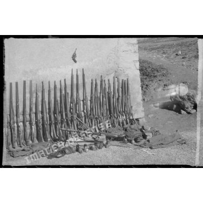 Dans une cour, exposition du materiel et de l'armement récupérés par les soldats du 8e RIM au cours d'une opération. [légende d'origine]