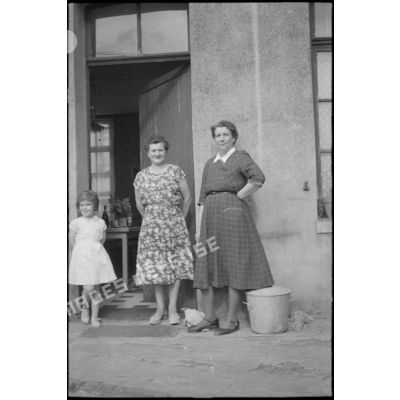 Dans le nord, portrait de la famille Smet. Portrait de deux femmes et d'une jeune fille sur le pas de porte. [légende d'origine]