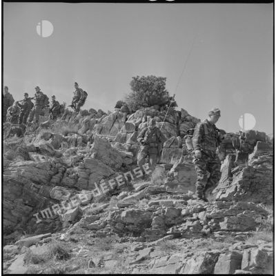 [Opération avec le commando Cobra aux monts des Ksour dans le secteur de Géryville. Soldats en progression dans des rochers.]