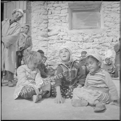 Tournée de secteur près de Tamesna et de Fenouane. Portraits de jeunes enfants qui jouent. Ils sont assis dans une cour. [légende d'origine]