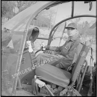 Portrait d'un pilote d'hélicoptère assis derrière les commandes de l'appareil. [légende d'origine]