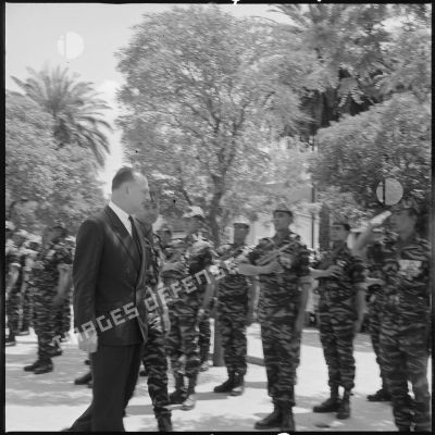 Le Délégué général du gouvernement en Algérie Paul Delouvrier accompagné du lieutenant Georges Grillot, chef du commando "Georges", passe en revue les commandos de chasse du secteur de Saïda. [légende d'origine]