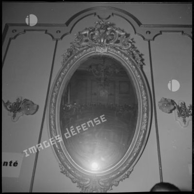 A l'Hôtel de ville de Saïda, vues d'un miroir dans lequel se reflètent les personnalités rassemblées à l'occasion de la visite du Délégué général du gouvernement en Algérie Paul Delouvrier. [légende d'origine]