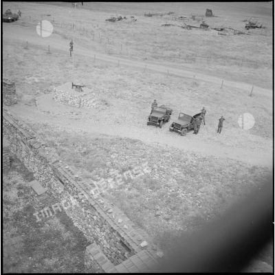 Vue aérienne du poste de Tircine. Des soldats et des jeeps sont visibles au sol. [légende d'origine]