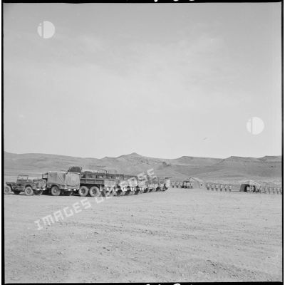 Vue du cantonnement du Kreider. Au premier plan, les véhicules sont stationnés tandis qu'en arrière-plan, les soldats se tiennent au garde-à-vous devant leurs tentes. [légende d'origine]