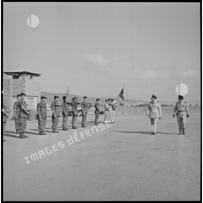 [A l'aéroport de Nazereg-Flinois, deux officiers passent en revue des commandos de chasse au garde-à-vous.]