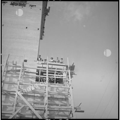 [Vue en contre-plongée d'ouvriers sur un bâtiment en construction aux docks coopératifs de Saïda.]