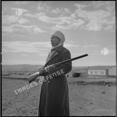 [Portrait d'un villageois appartenant à un groupe d'autodéfense. Debout, un fusil dans les mains, il protège la population algérienne logée dans le centre de regroupement de la ferme Cazorla.]