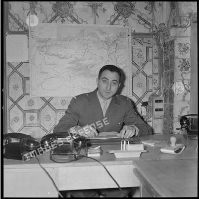 [Portrait d'un soldat à son bureau probablement au cantonnement de Sidi Maarouf. Une carte du département de Constantine est accrochée au mur.]