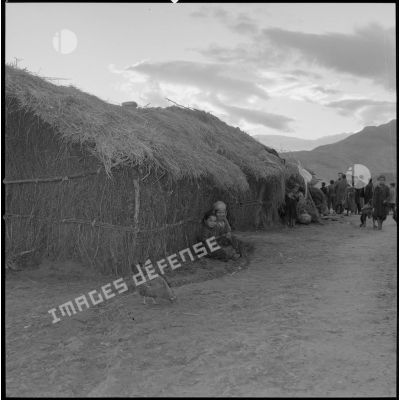[Enfants assis devant une habitation traditionnelle d'un village kabyle.]