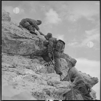 [Opération en Kabylie avec le 2/8e RIM dans le secteur du Djurdjura. Soldats escaladant un rocher.]