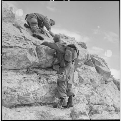 [Opération en Kabylie avec le 2/8e RIM dans le secteur du Djurdjura. Soldats escaladant un rocher.]