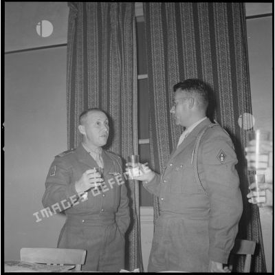 [PC du 2/8e RIM à Tissemiran-Haut. Soldats buvant un apéritif au cours de la remise de certificat de bonne conduite du chef de bataillon Dastillung, à gauche, au capitaine Audric, à droite.]