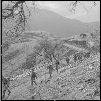 [Opération en Kabylie avec le 2/8e RIM. Soldats progressant en colonne sur une piste.]