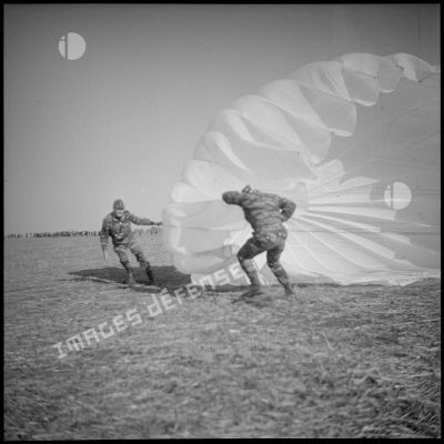 [Entraînement dans le département de Saïda. Arthur Smet, photographe du 8e RIM, apportant son aide à un soldat parachuté sur une zone de saut.]