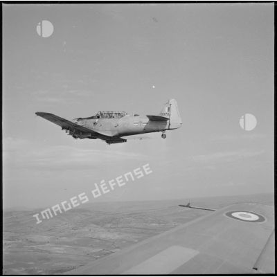 [Avion North American T-6 portant l'insigne de la 20/72e escadrille d'aviation légère d'appui (EALA) en vol de reconnaissance.]