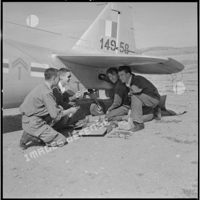 [Aérodrome de Nazereg-Flinois. A droite, un pilote d'escadrille d'aviation légère d'appui (EALA) charge des munitions sur un avion North American T-6.]