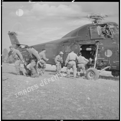 [Opération avec le commando Georges dans le secteur de Fenouane, près de la ferme Garrigues. Soldats débarquant les corps des combattants transportés par hélicoptère du GHAN (groupe d'hélicoptères de l'aéronautique navale).]