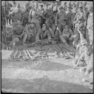 [Opération avec le commando Georges dans le secteur de Fenouane, près de la ferme Garrigues. Soldats posant devant les armes récupérées dont un fusil-mitrailleur.]