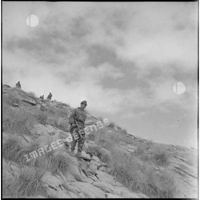 [Soldat du commando Cobra progressant dans les monts des Ksour avec son pistolet-mitrailleur.]
