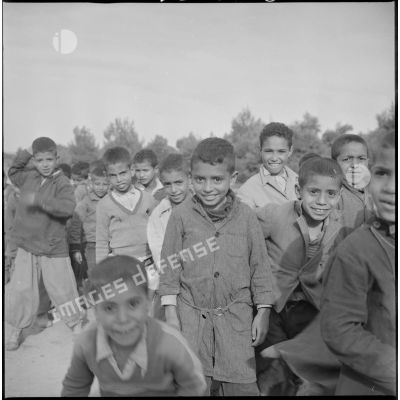 [Groupe d'enfants algériens souriant face à l'objectif du photographe à  Aïn Skhouna.]