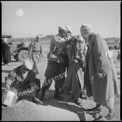 [Distribution de grain auprès d'une Algérienne par des soldats près de Saïda.]