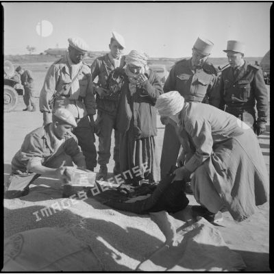 [Soldats distribuant du grain à un homme algérien près de Saïda.]