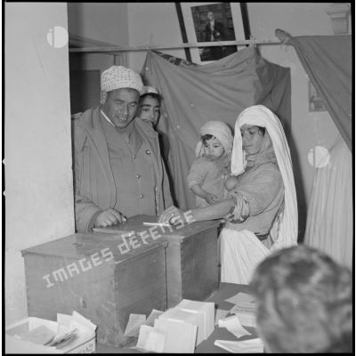 [Algérienne déposant son bulletin de vote dans une urne à Wagram.]