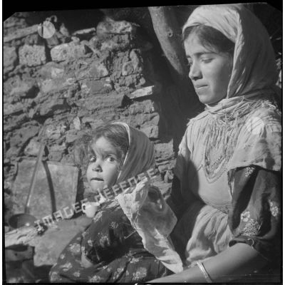 [Portrait d'une enfant algérien dans les bras de sa mère près de Saïda.]