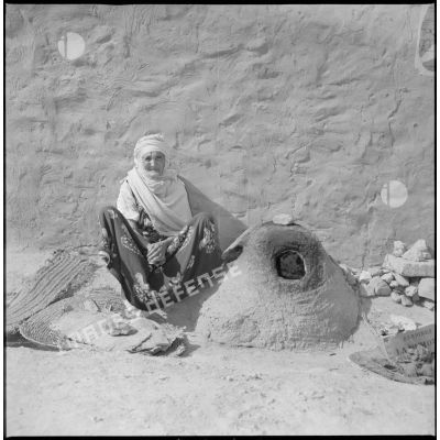 [Algérienne posant près d'un kanoun dans un village du secteur de Franchetti.]