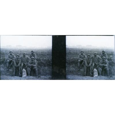 [Portrait de cinq soldats posant avec un obus.]