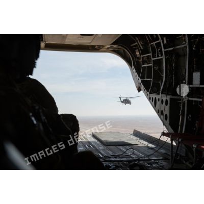 Porte de la soute d'un hélicoptère CH-47 Chinook américain transportant les bigors du contingent du 3e RAMa en transit depuis Al-Asad Air Basa vers Al-Qaïm en Irak. Ce dernier est escorté par un UH-60L Blackhawk.